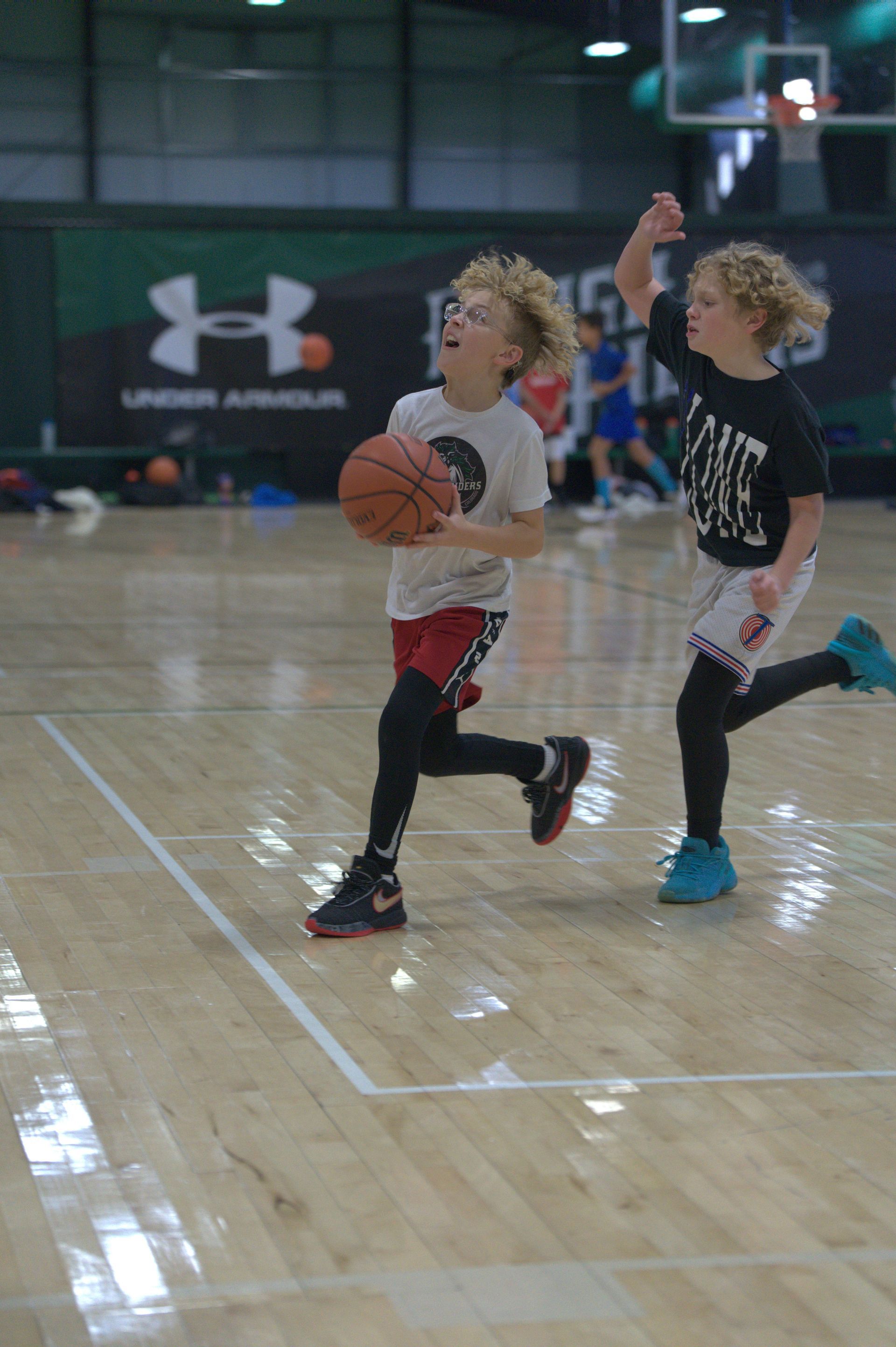 Youth basketball players competing in a game while learning skills, toughness, teamwork, and how to