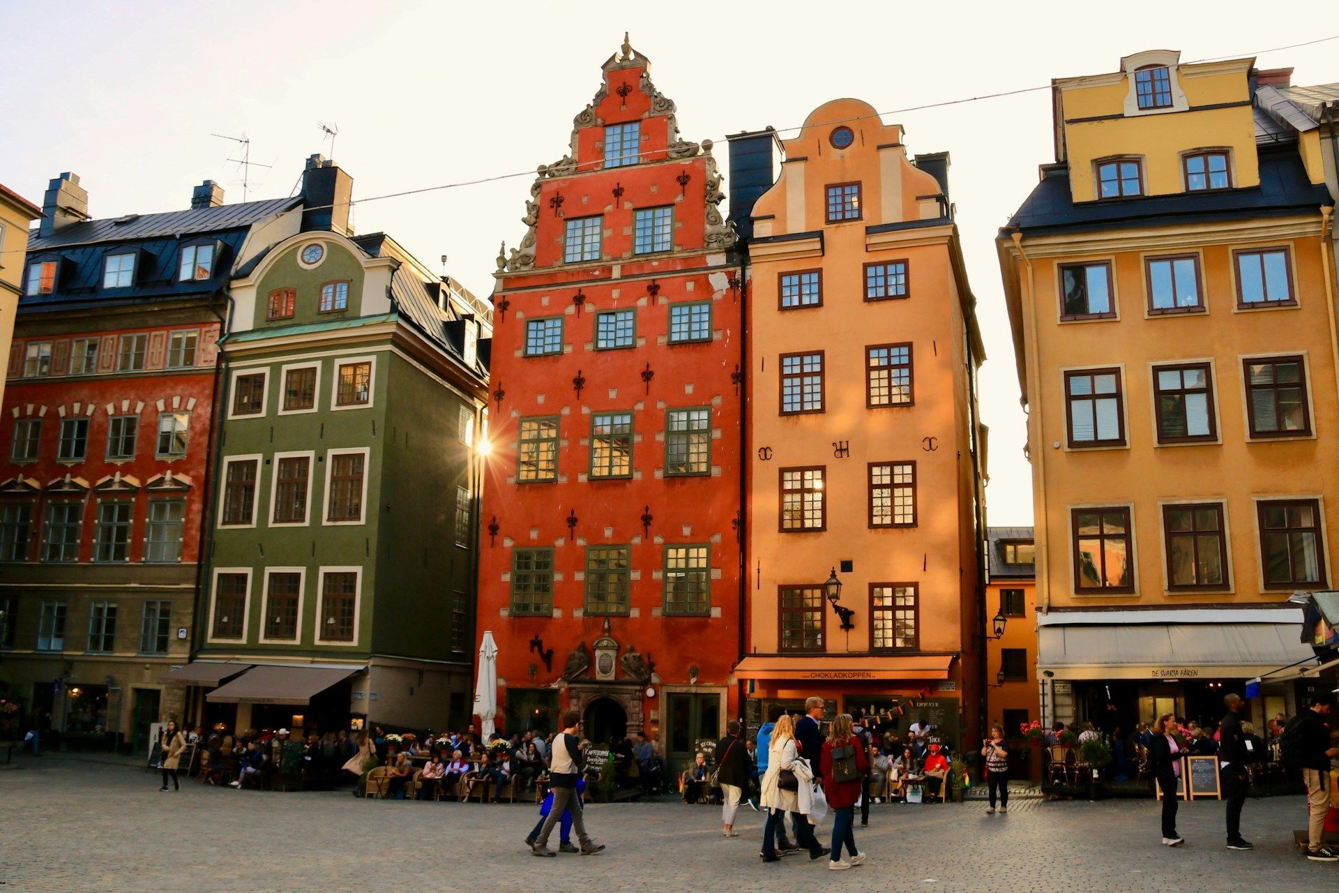Stortorget square in Stockholm featuring narrow, colorful buildings with steep gables and street-level shops and cafes.