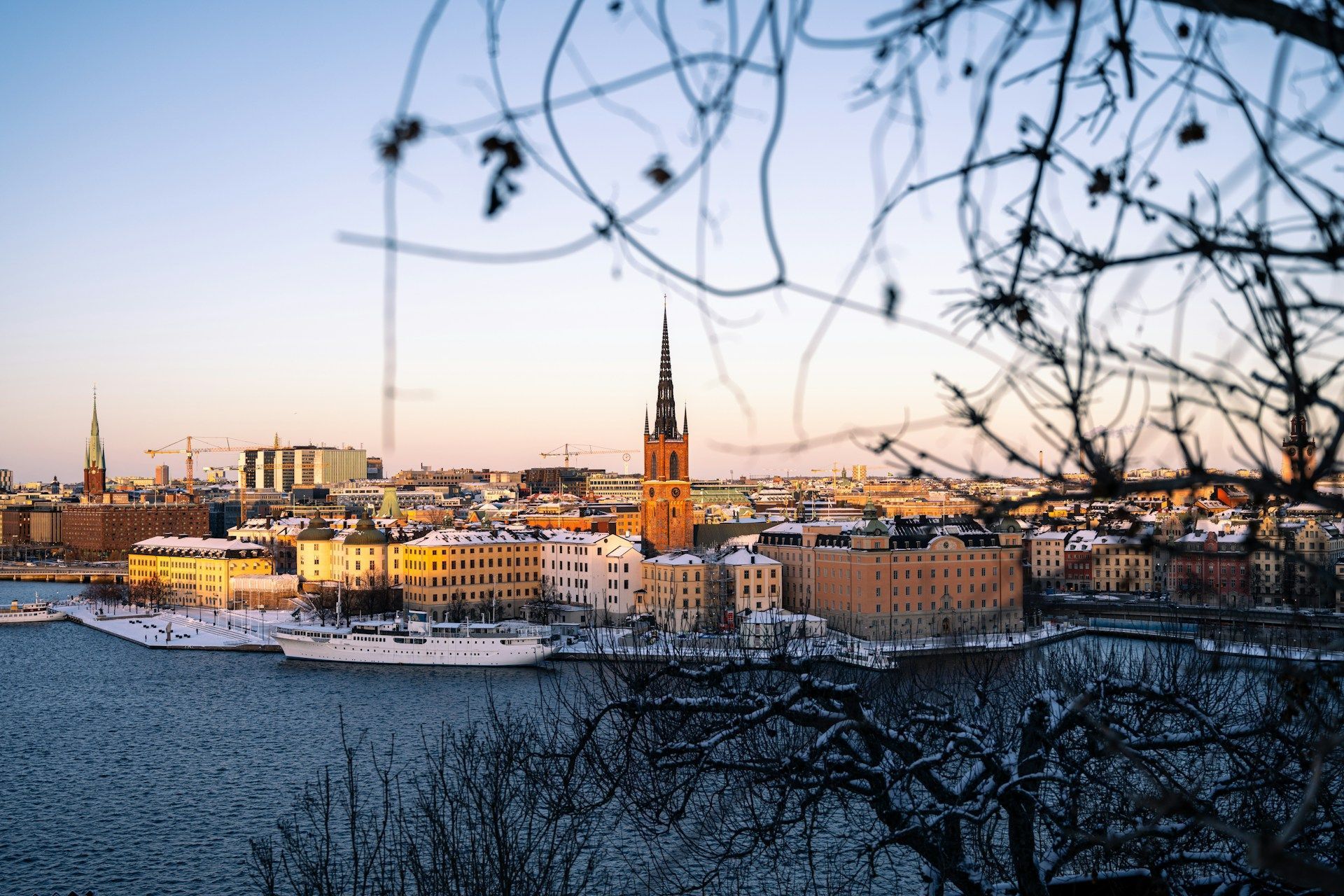 Snowy waterfront Stockholm at sunset with the Riddarholmen church spire
