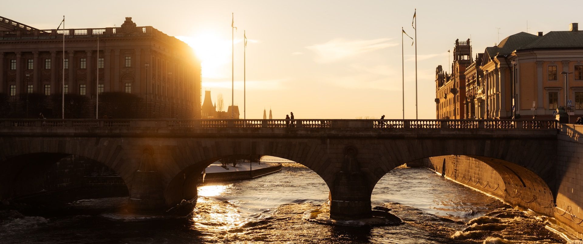 Golden hour at Strömbron bridge, Stockholm, with the sun setting over Norrström