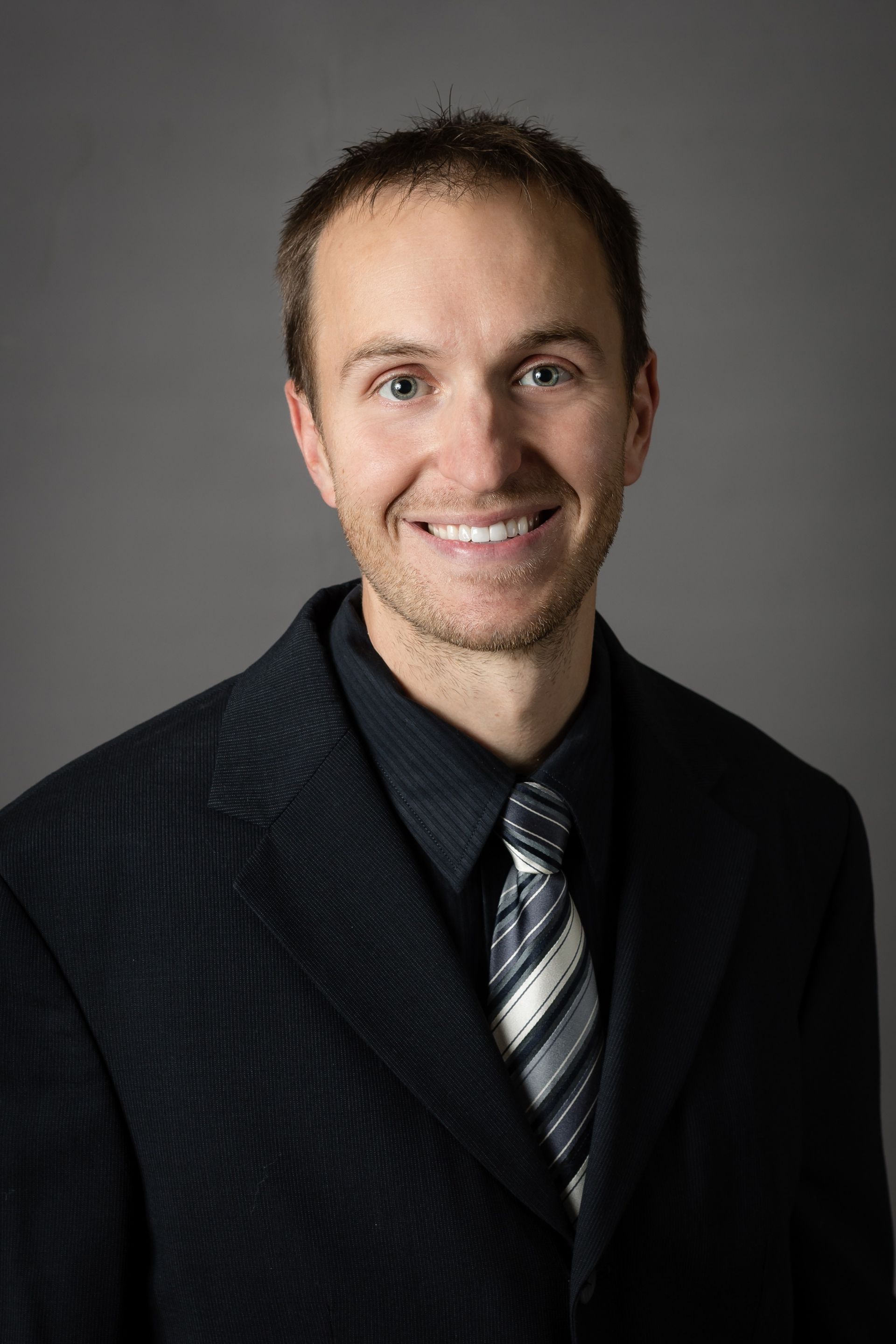 A man in a suit and tie is smiling for the camera.