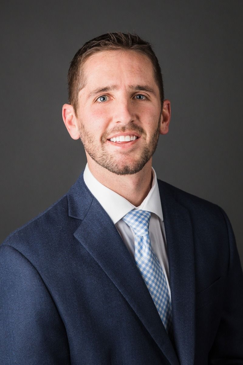 A man in a suit and tie is smiling for the camera.