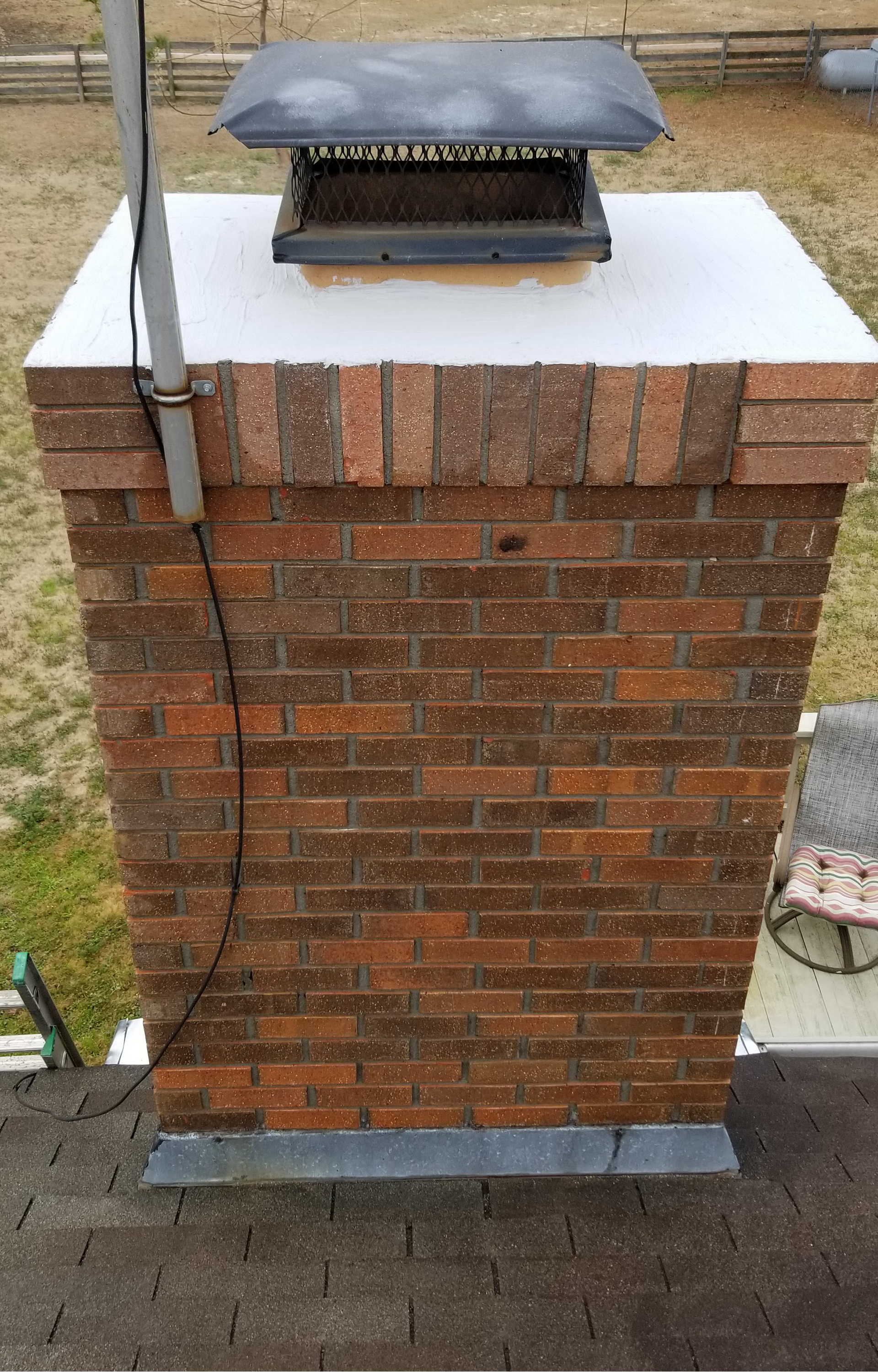 a brick chimney is sitting on top of a roof .