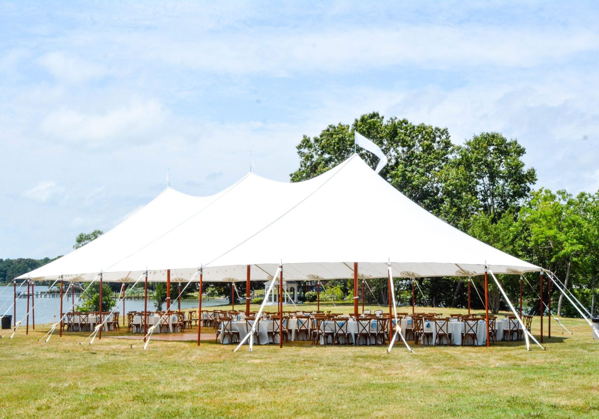A large white tent with tables and chairs underneath it