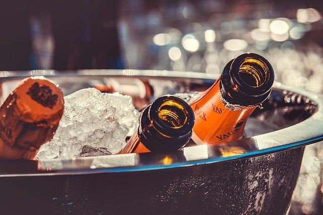 Two bottles of champagne are sitting in a bucket of ice.