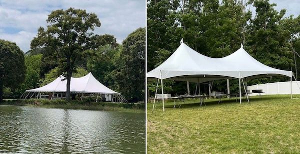 A large white tent is sitting on top of a lush green field next to a lake.