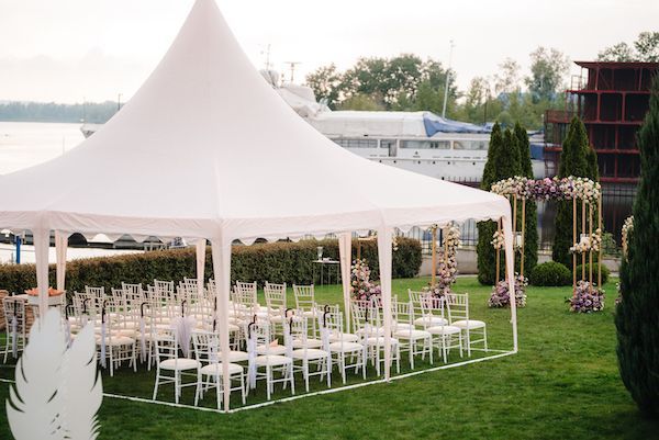 A white tent is sitting on top of a lush green field.