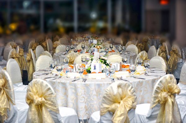A banquet room with tables and chairs set up for a wedding reception.