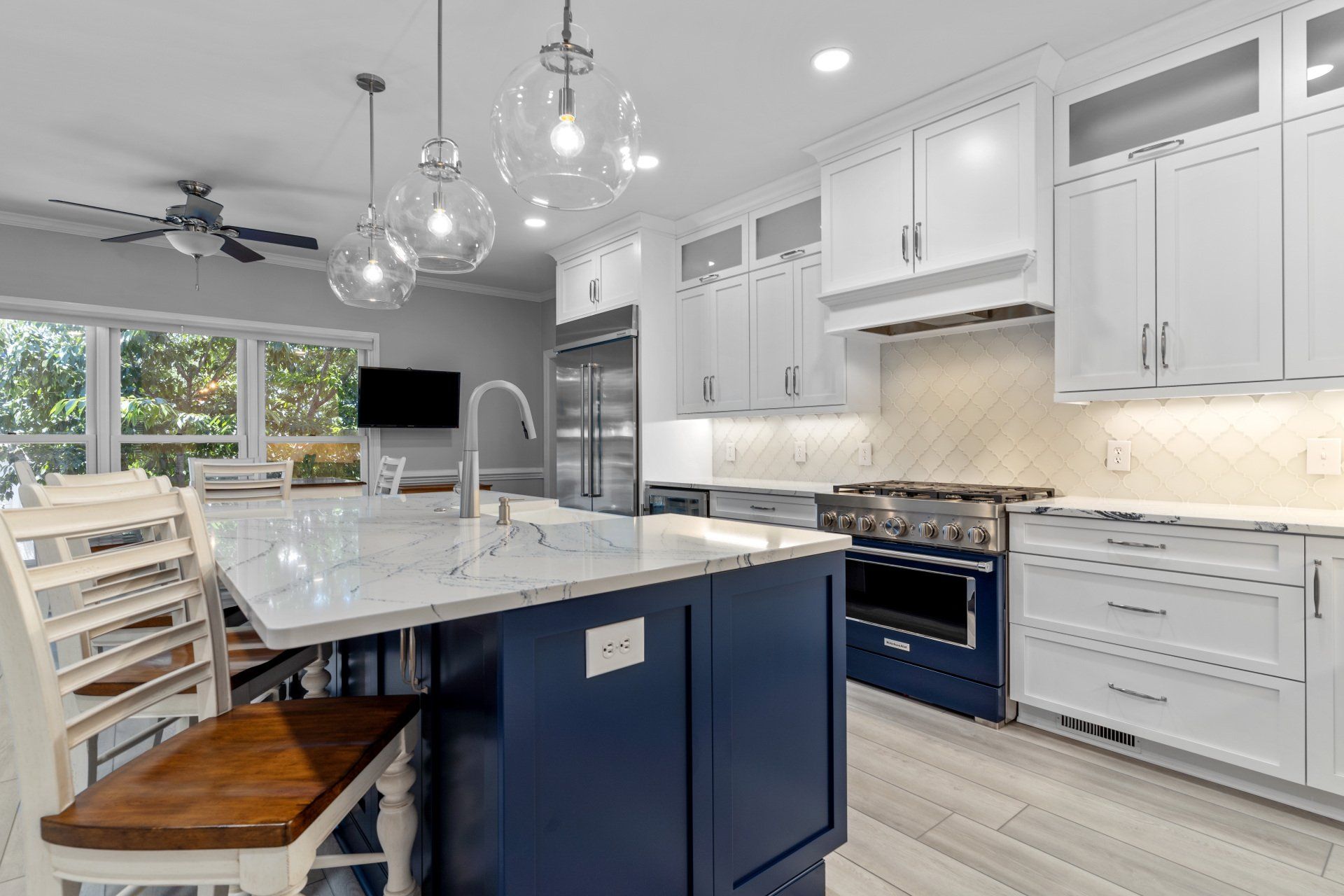 Kitchen remodel in Wilmington, NC featuring a navy blue island and white custom cabinetry.