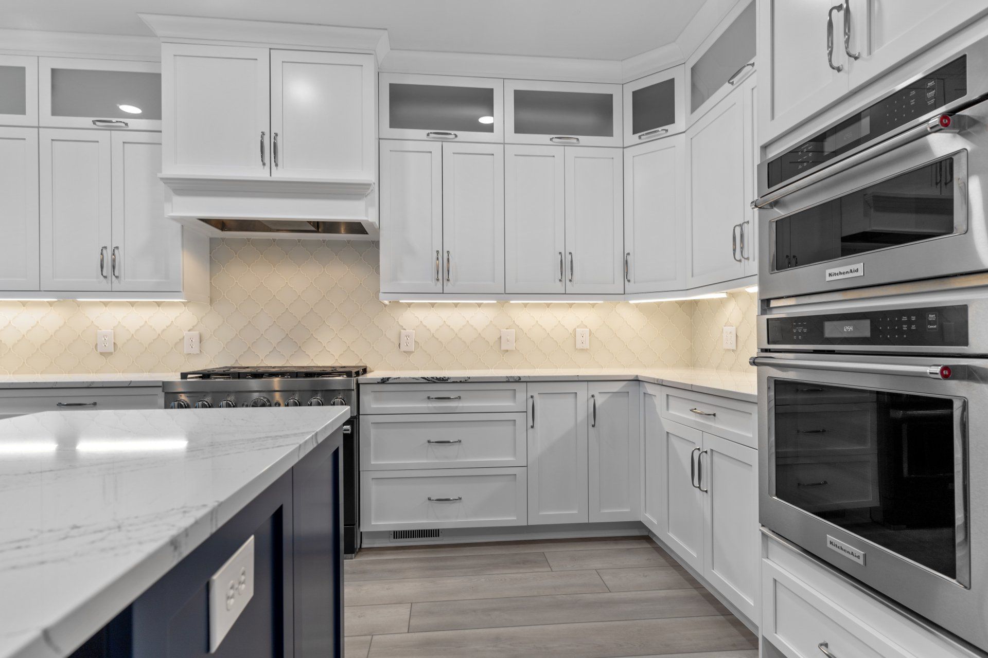 White shaker cabinets with frost glass upper cabinets in renovated kitchen.