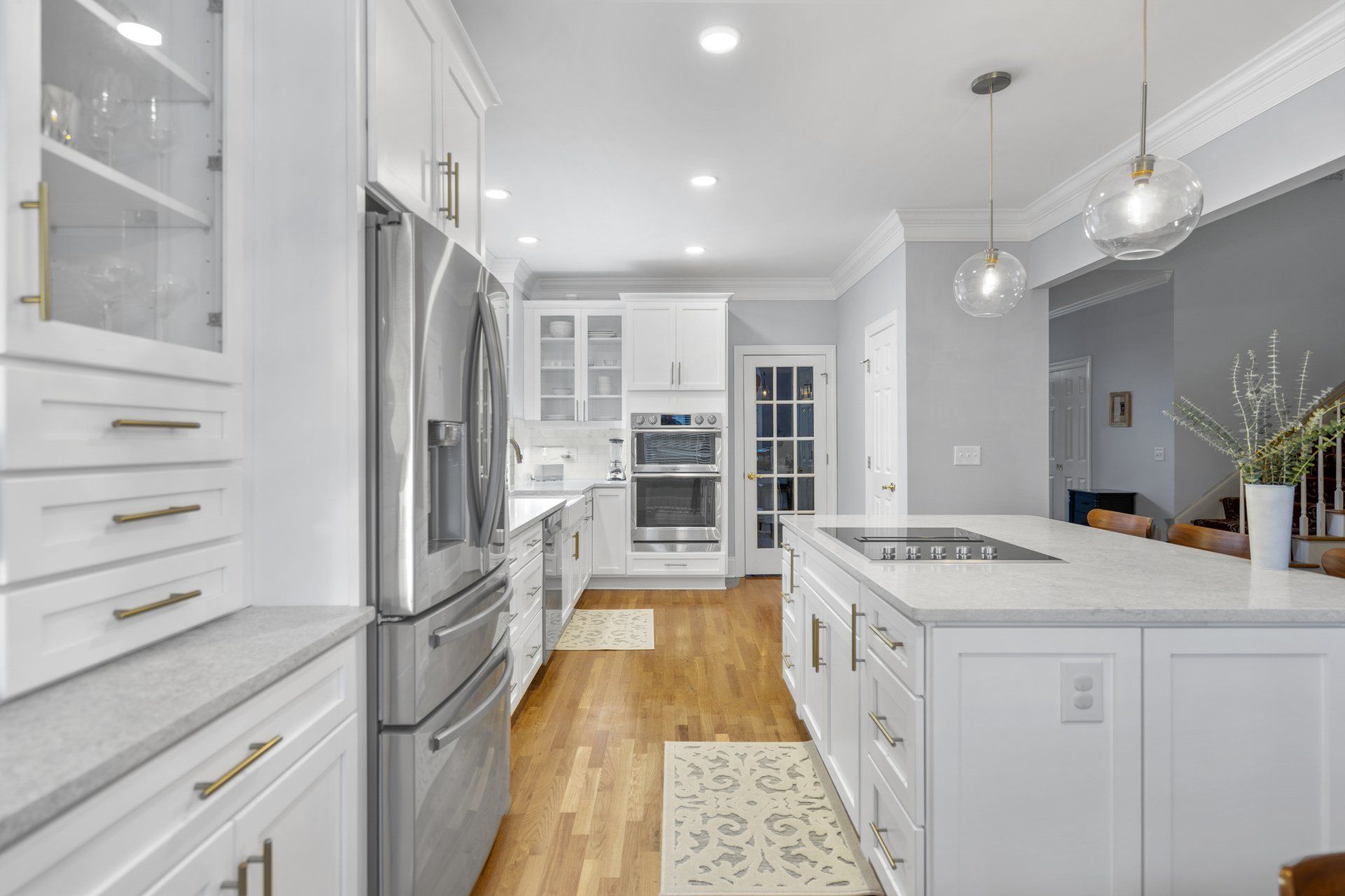 White shaker kitchen with large island and double wall ovens.