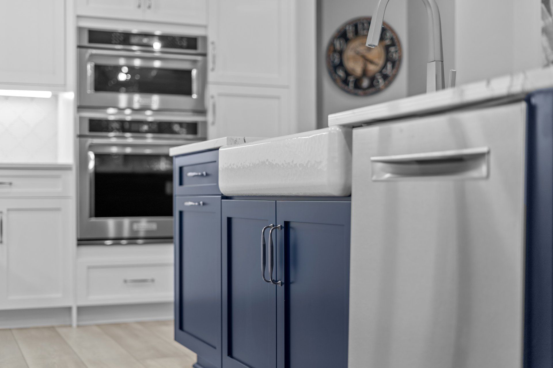 Navy blue shaker kitchen island with farm house style sink and brushed nickel Blum hardware