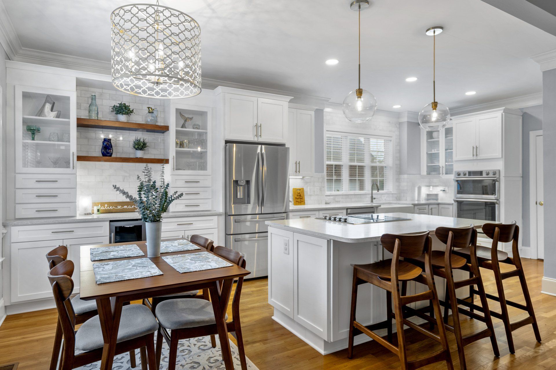 Farmhouse style kitchen renovation in Wilmington, NC with white cabinets, island cooktop range, and gold fixtures.