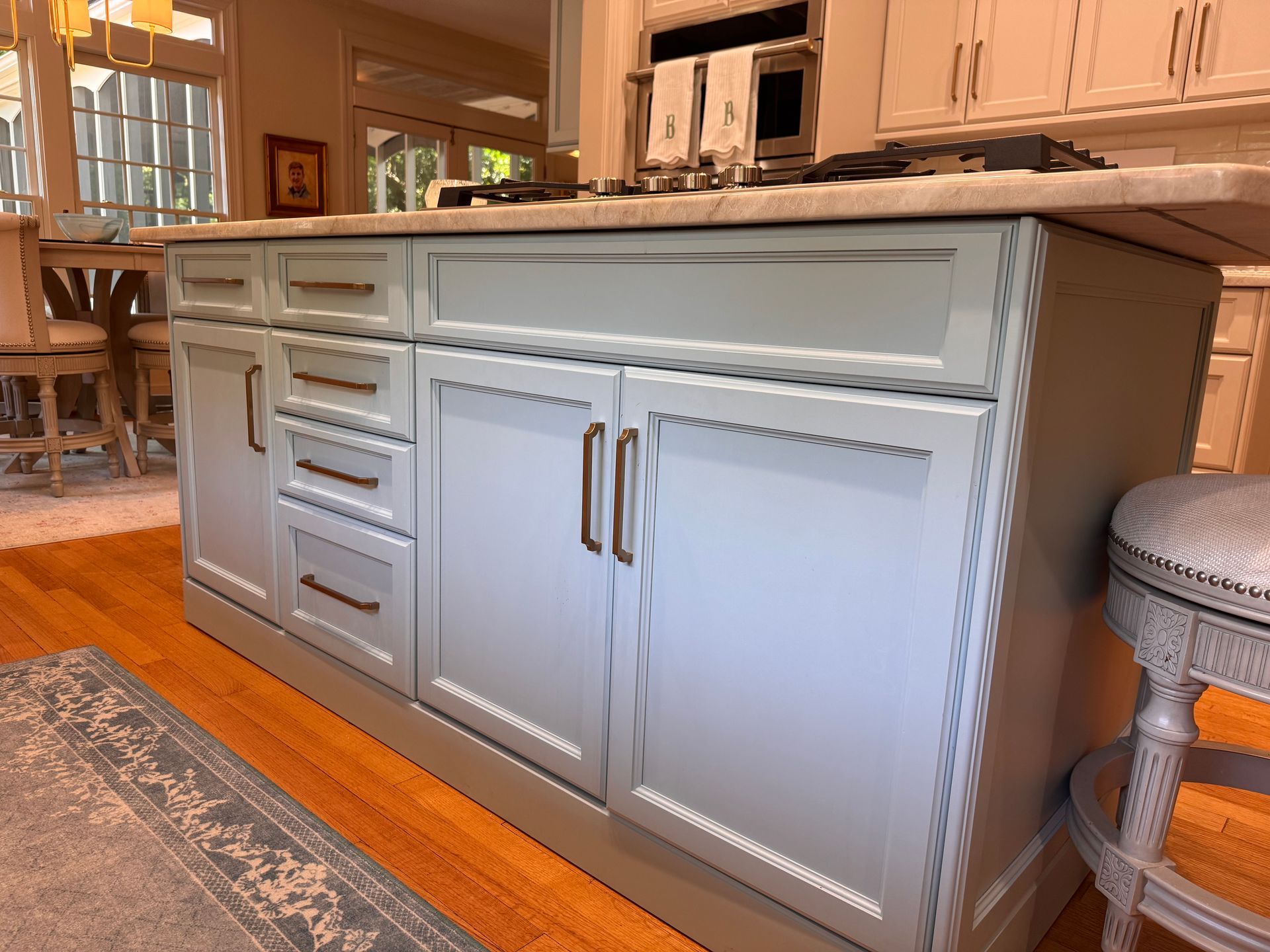 Coastal blue kitchen island with roman brushed gold pull hardware.