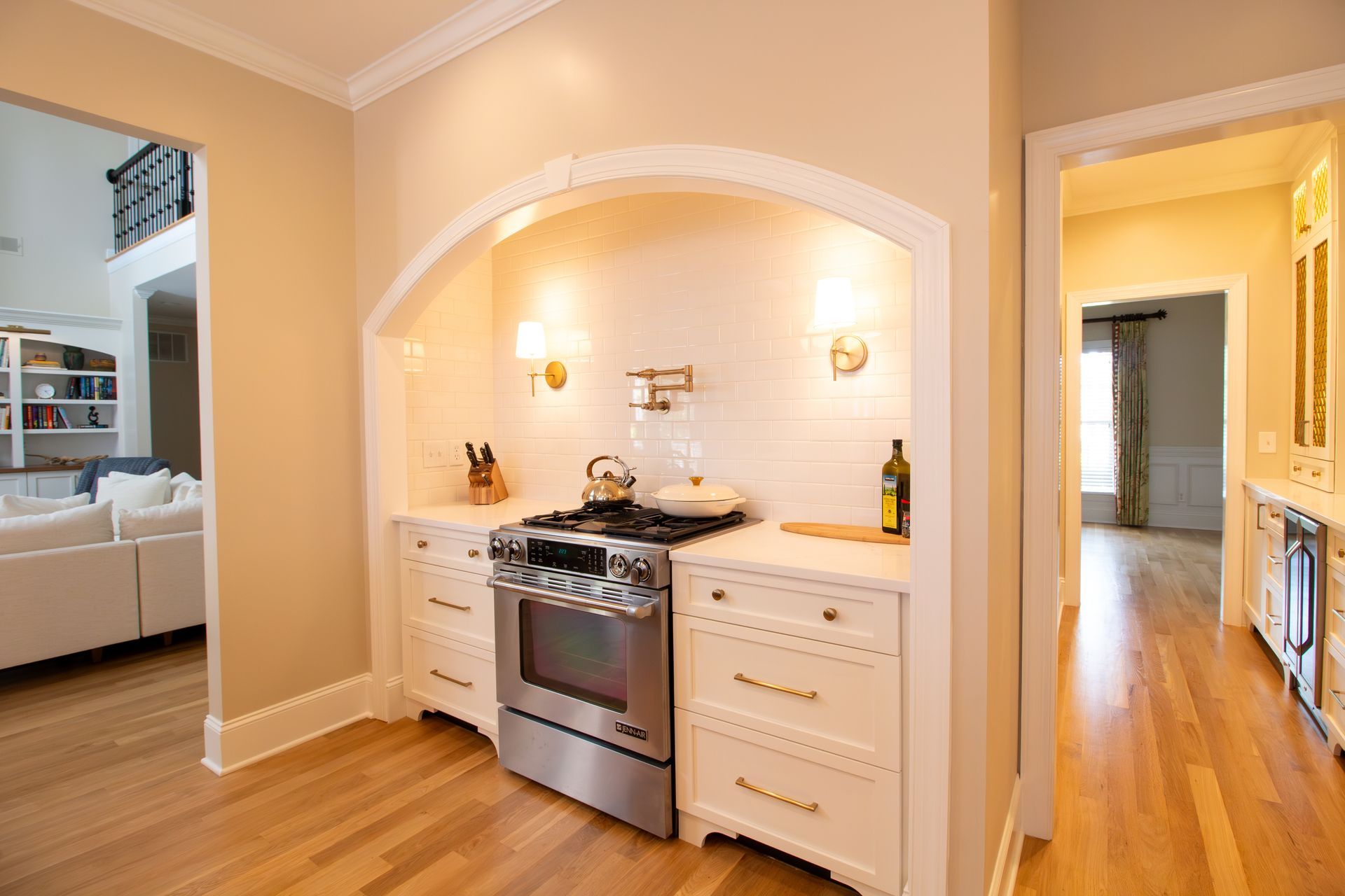 White and gold kitchen with arched cooking nook.