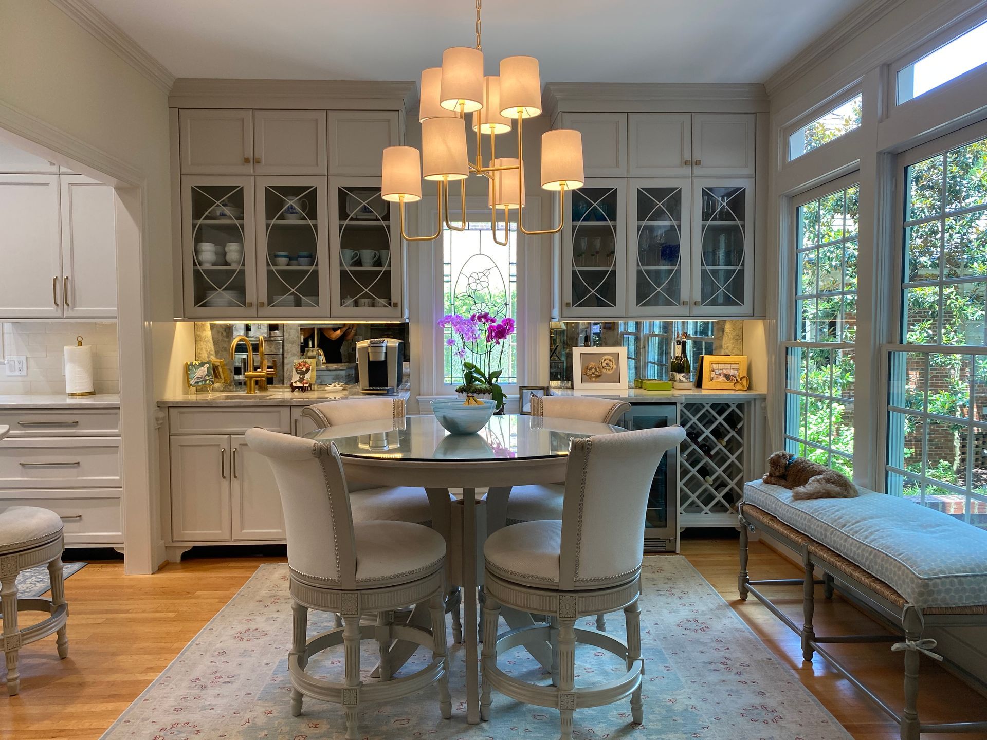 Dining room area with chandelier over table and additional kitchen cabinet storage in the behind including a wine rack and coffee bar.