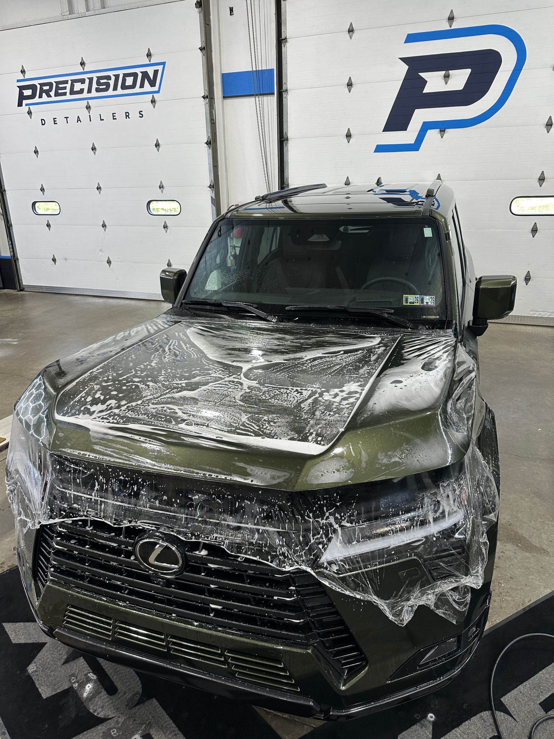 A man in a grey shirt is working on a car