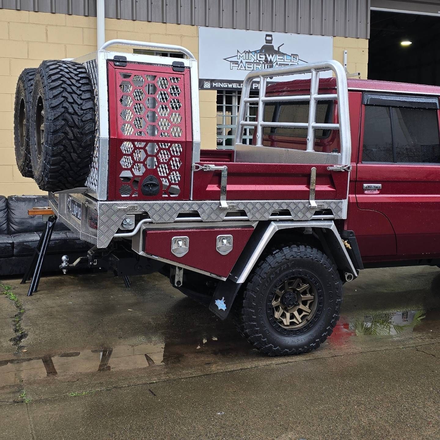 Red pickup truck with custom aluminum tray bed, spare tires, and gold rims — Mingweld Fabrication in Bungalow, QLD 