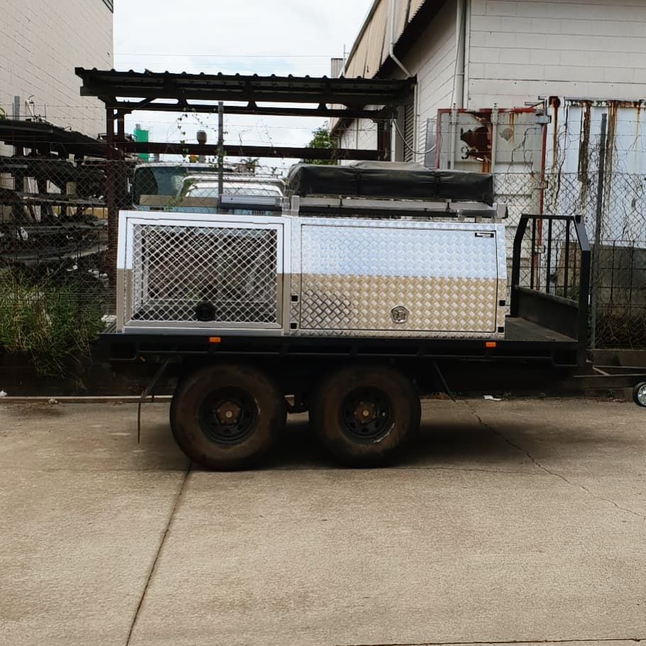 A utility trailer with a metal storage unit, parked on concrete — Mingweld Fabrication in Bungalow, QLD 