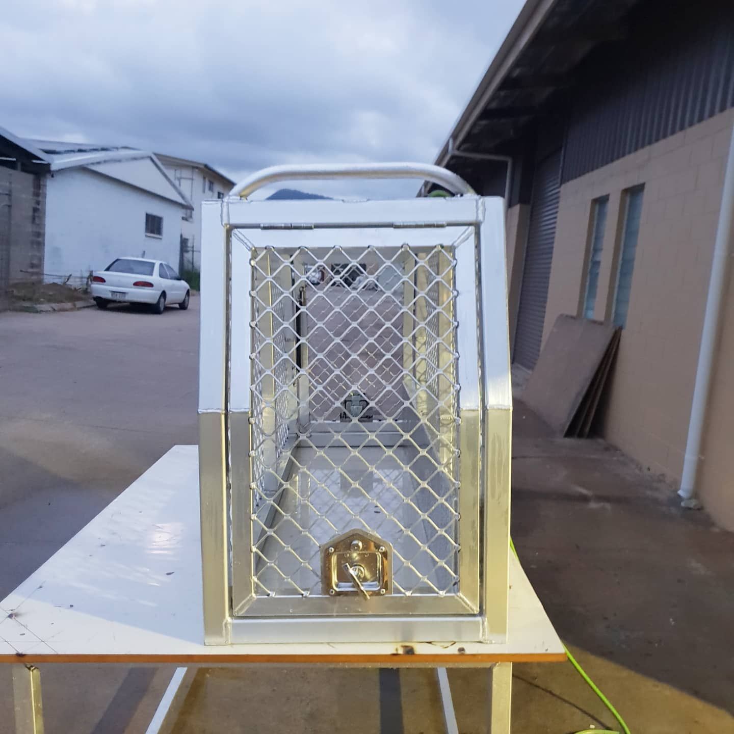 Metal pet carrier with wire mesh door, on a table outdoors — Mingweld Fabrication in Bungalow, QLD