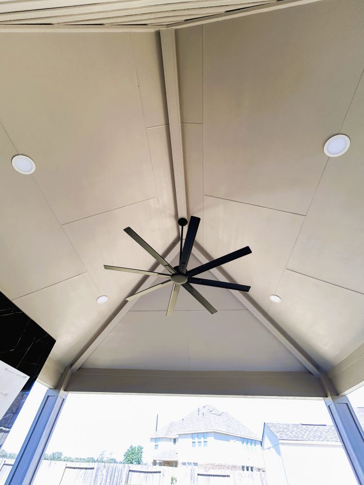 Tan vaulted patio ceiling with ceiling fan and recessed lights.