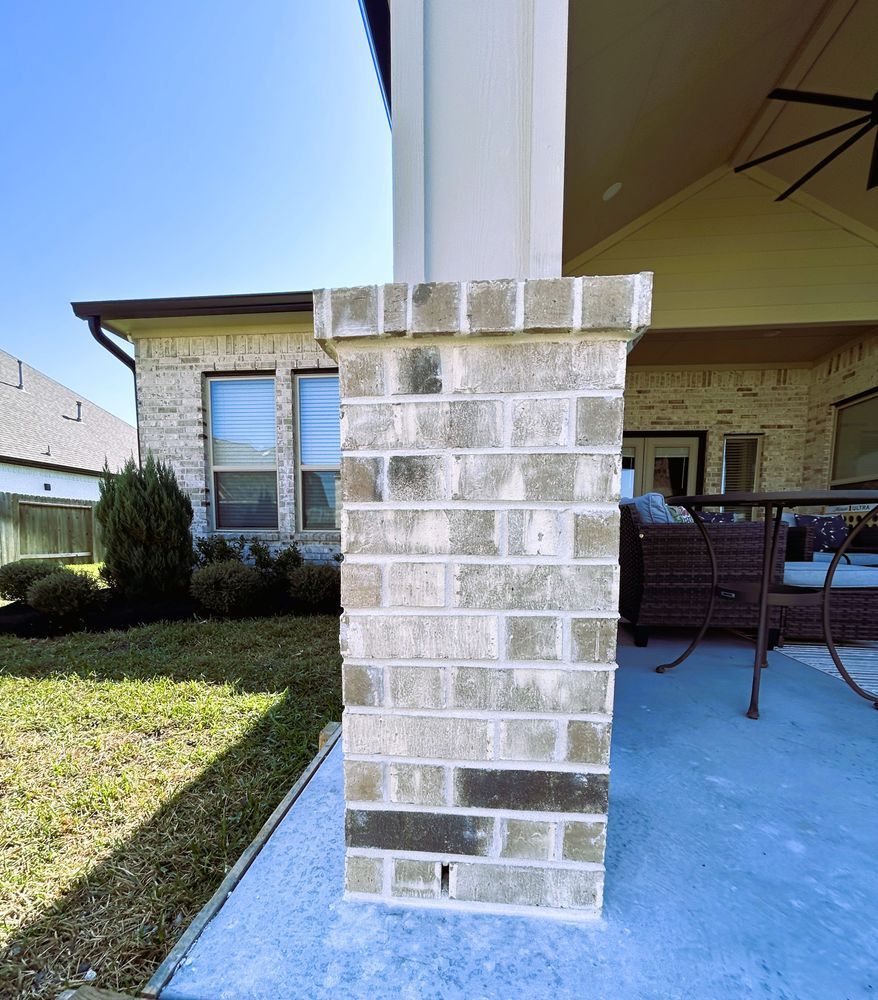 Brick pillar on a porch, beside a grassy yard. The pillar is light grey.