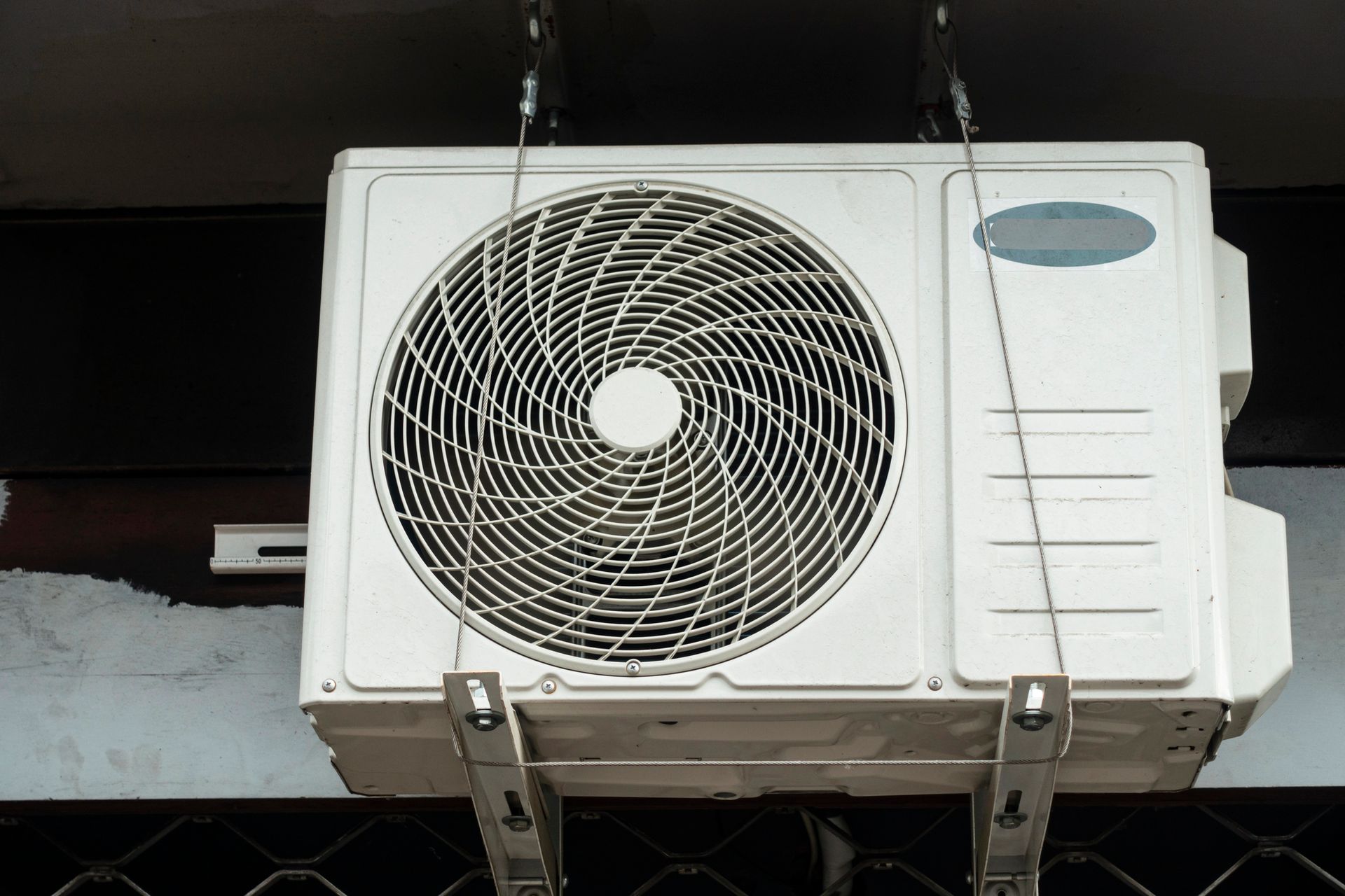 Condizionatore d'aria bianco montato a parete con griglia di ventilazione.