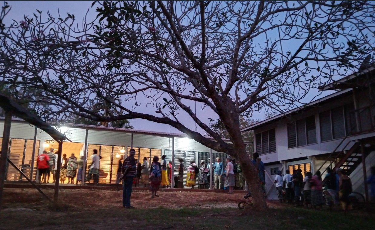 A group of people are standing outside of a building at night