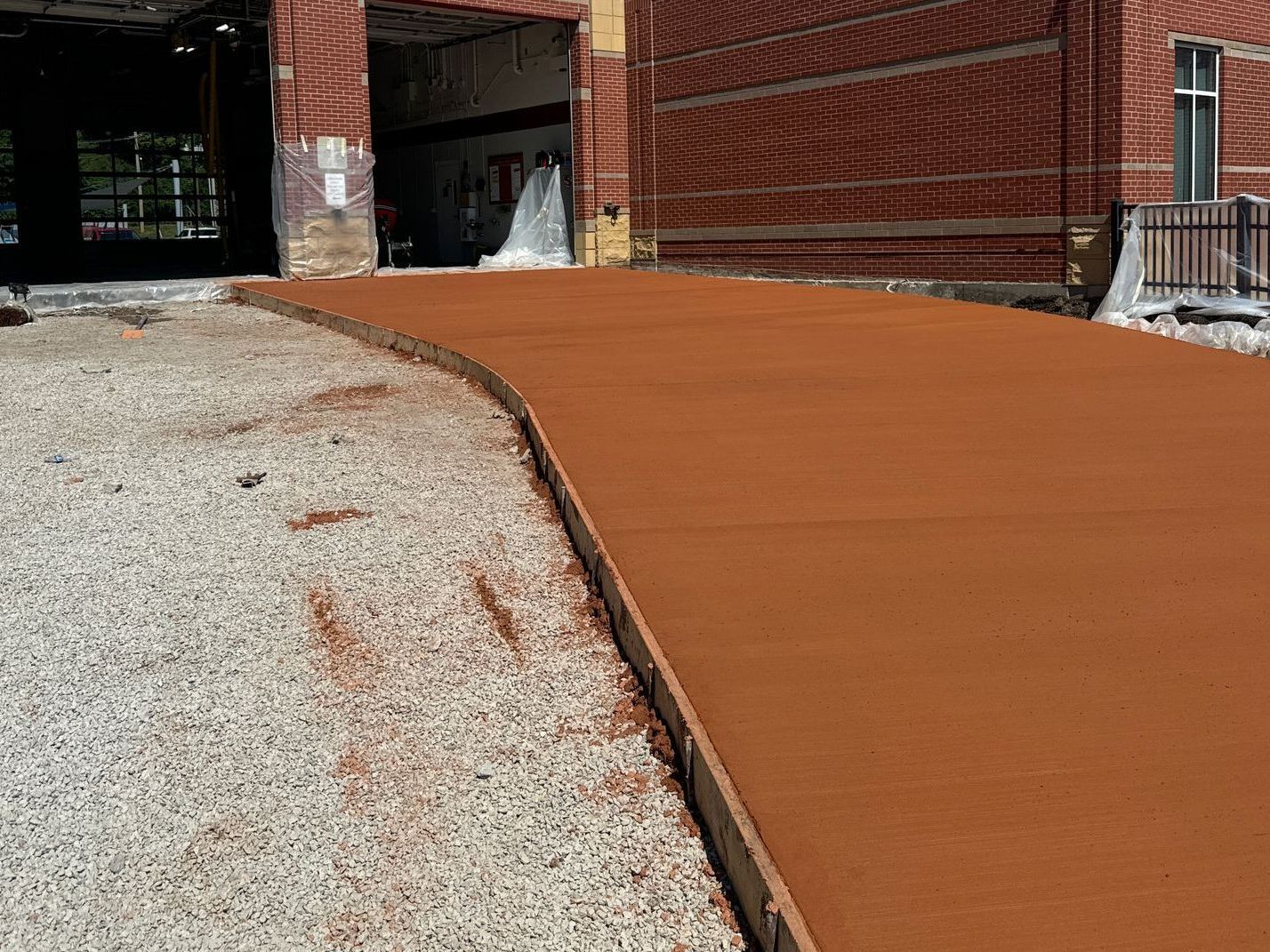 A concrete walkway is being built in front of a brick building.