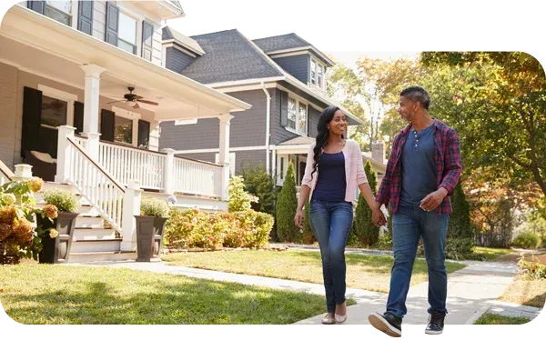 Couple walks past a newly roofed home, illustrating how to join Edge Roofing’s referral program.