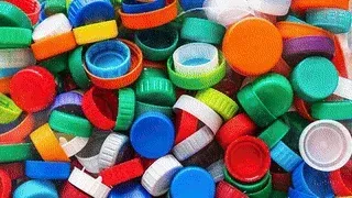 Colorful assortment of plastic bottle caps, recycled materials used in Brava composite roofing solutions, & sustainability!