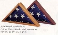 Two wooden triangular wall mounts holding folded U.S. flags, in oak and cherry finishes.