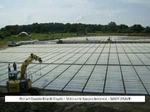 Excavator on a large gridded concrete slab, with a banner reading “SAVE GRACE” at the bottom.