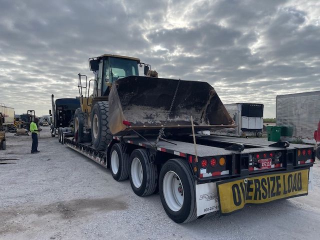 An oversized load sign is on the back of a semi truck