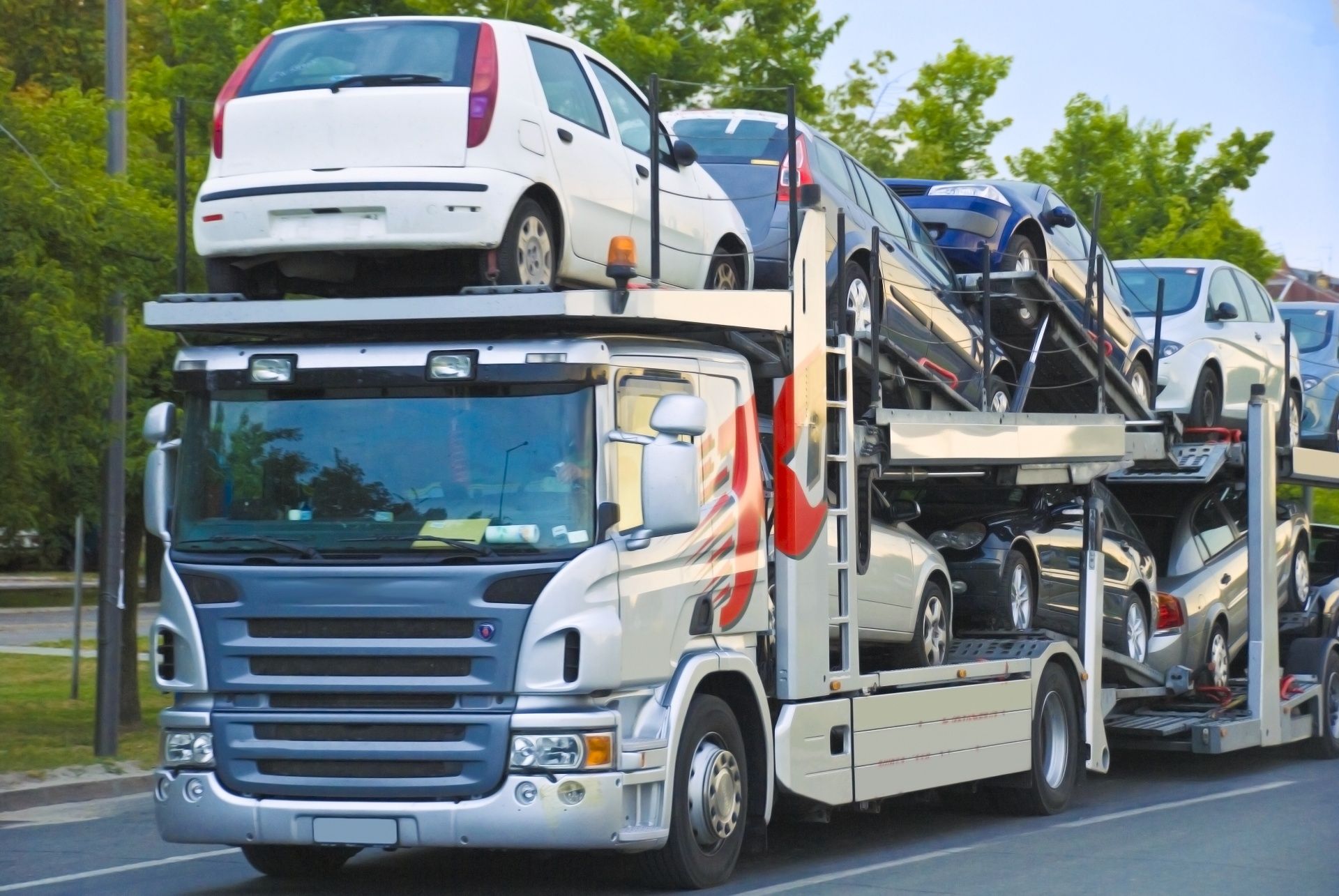 A car carrier truck is carrying a bunch of cars on top of it.