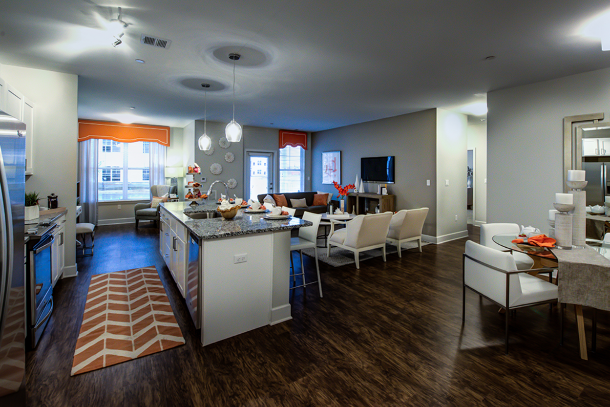 A living room with hardwood floors and a large island in the middle.