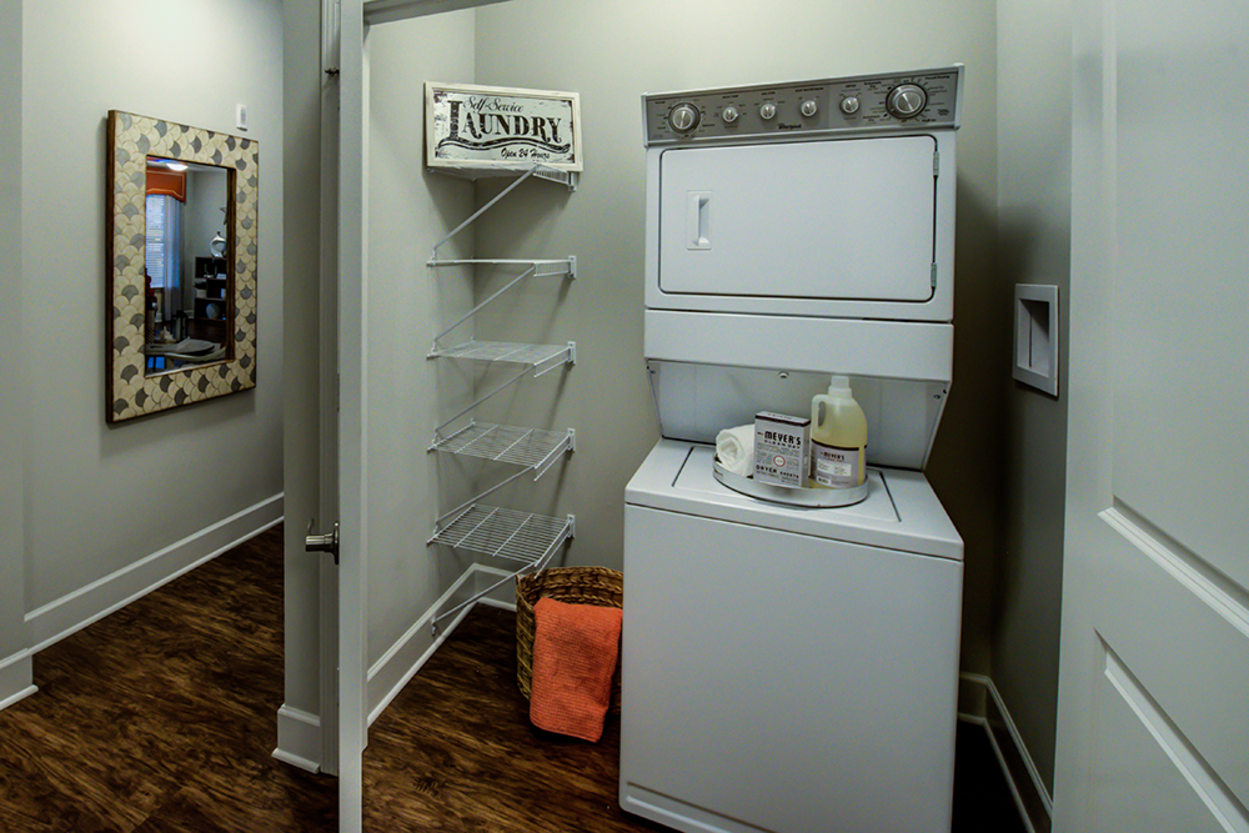 A laundry room with a washer and dryer and a mirror.