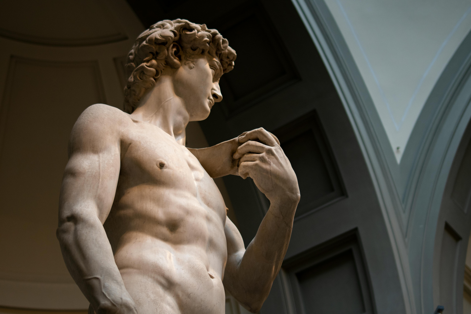 A statue of a man without a shirt is standing in a room.