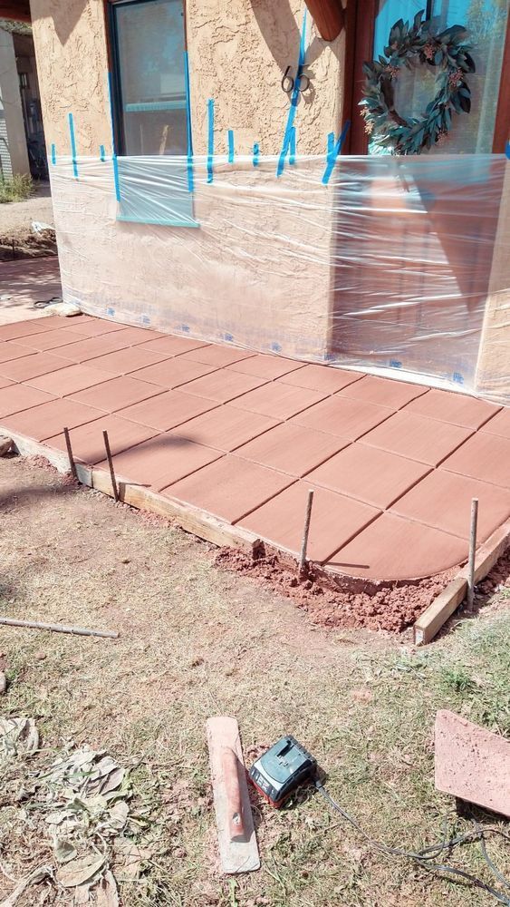 New concrete porch being installed; reddish-brown color, wood formwork, metal rebar.