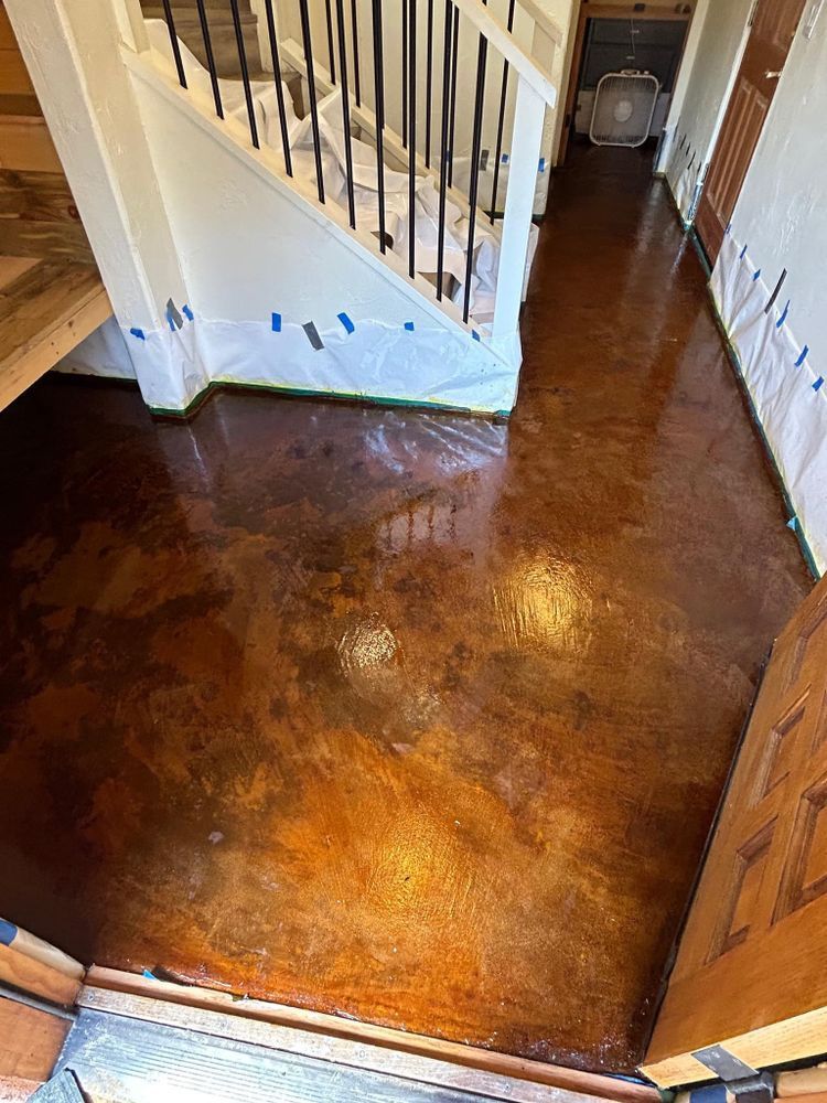 Metallic copper-colored floor in a foyer, leading to a staircase.