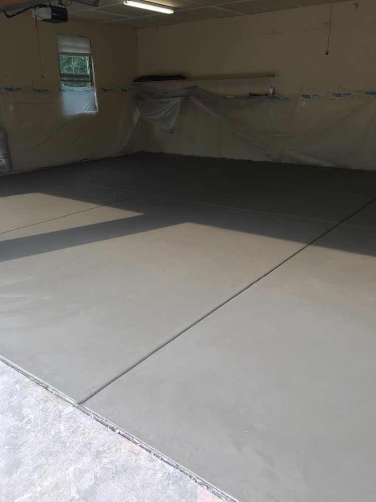 Newly poured concrete garage floor, light gray, with a control joint.