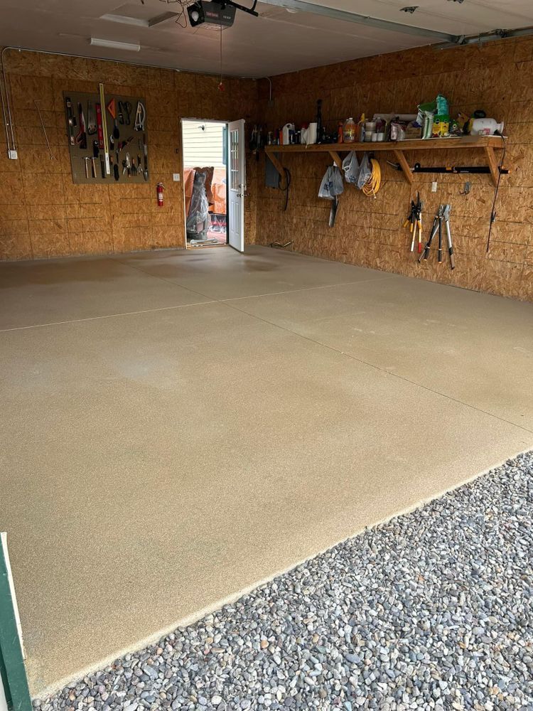 Empty garage with smooth, light-brown concrete floor.