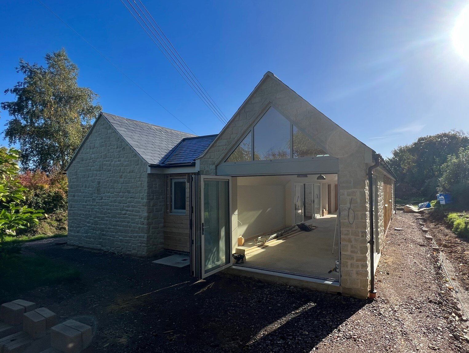 Esdon Architecture. New build Tisbury, Wiltshire, outside view. Stonework. Bi-folding doors Esdon Architecture. Wiltshire and Hampshire Architect. New build, stone house with bi-folding doors, Tisbury, Wiltshire. Planning application, planning permission. Working drawings, building control, site visit, construction and design.