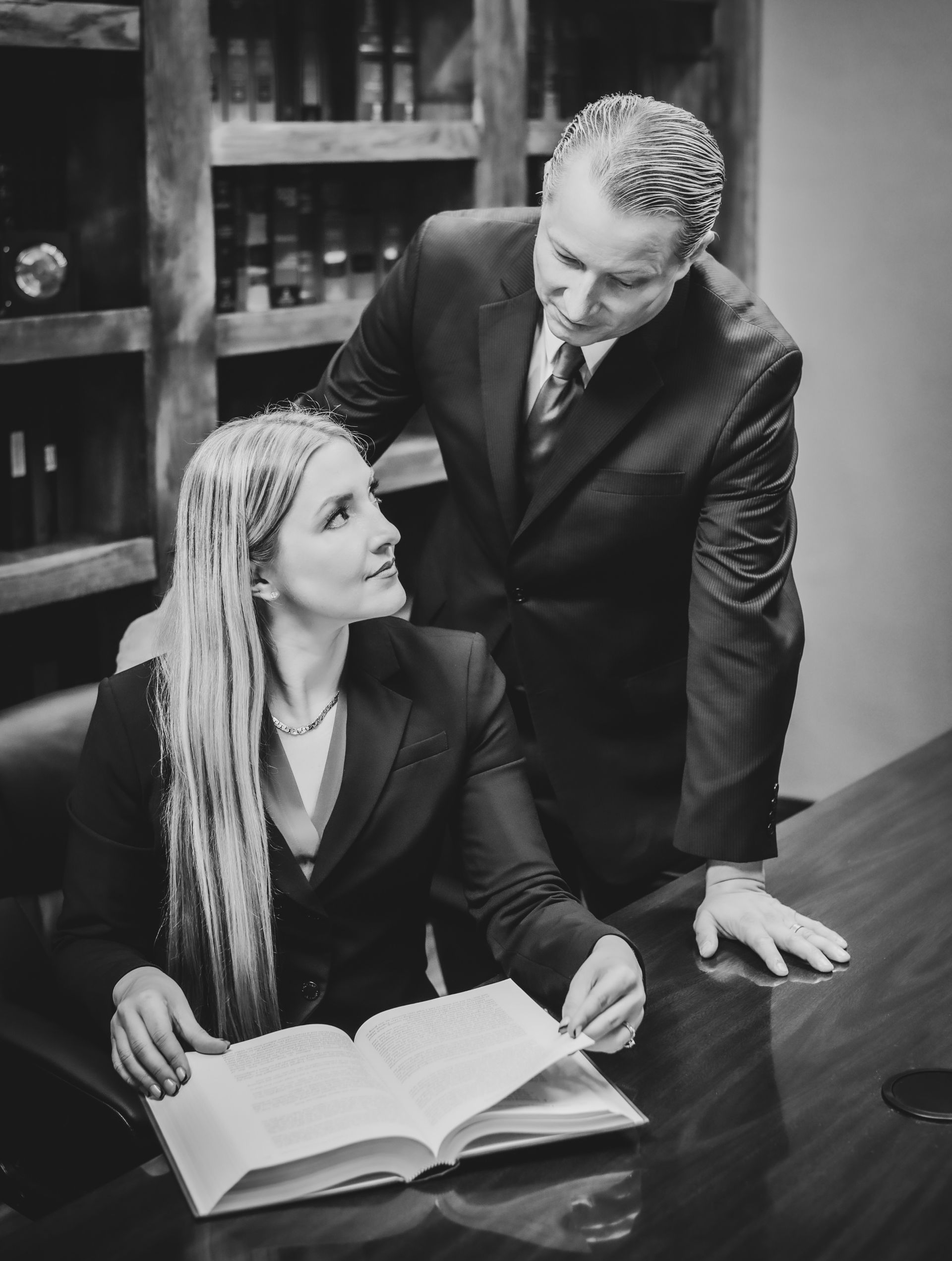 Fort Myers bankruptcy attorneys Veronica Batt and Adrian Lynn reviewing a book together at Lynn Law Group.
