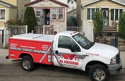 A white truck is parked in front of a house.