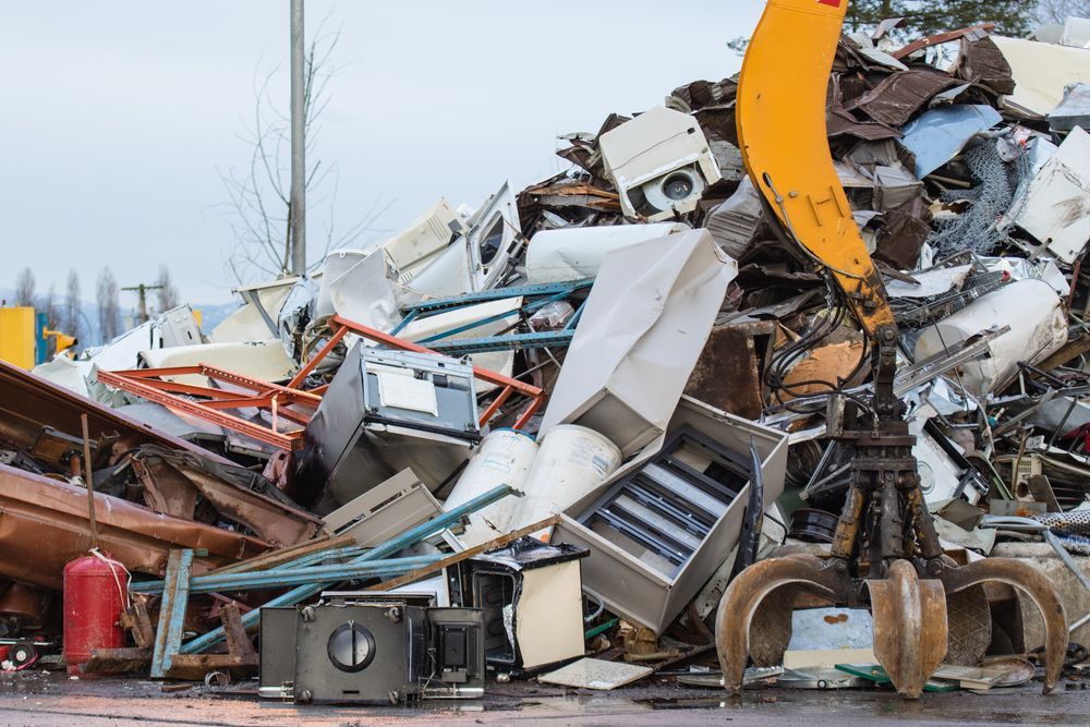 A Pile Of Scrap Metal Is Being Picked Up By A Crane — East Coast Metal Recycling In Tugun, QLD