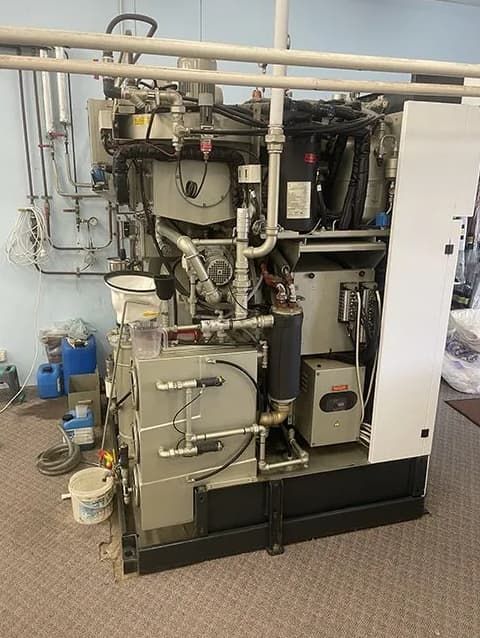 A Large Machine Is Sitting In A Room With A Lot Of Pipes — East Coast Metal Recycling In Southport, QLD