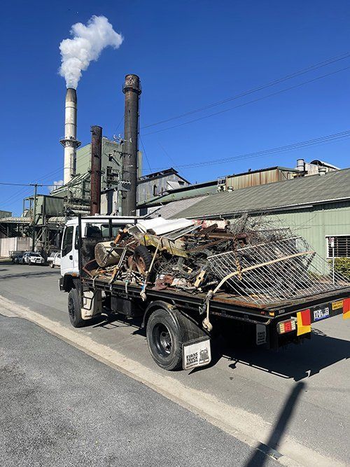 A Truck Is Parked On The Side Of The Road In Front Of A Factory — East Coast Metal Recycling In Tugun, QLD