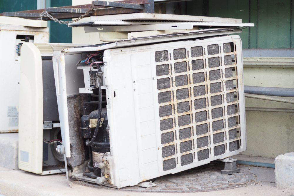 A Broken Air Conditioner Is Sitting On The Ground — East Coast Metal Recycling In Southport, QLD