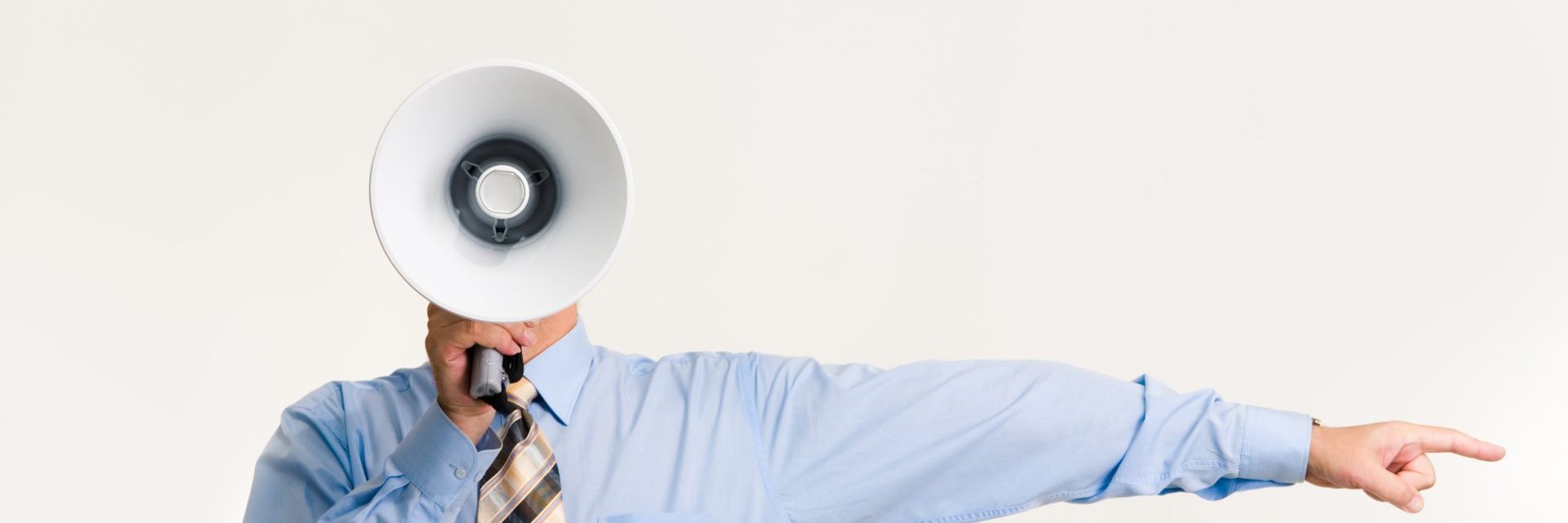 Person in a blue shirt holding a megaphone and pointing to the right